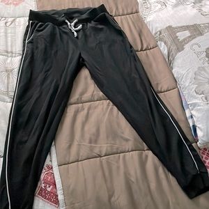 Black sweatpants with white lining on side.